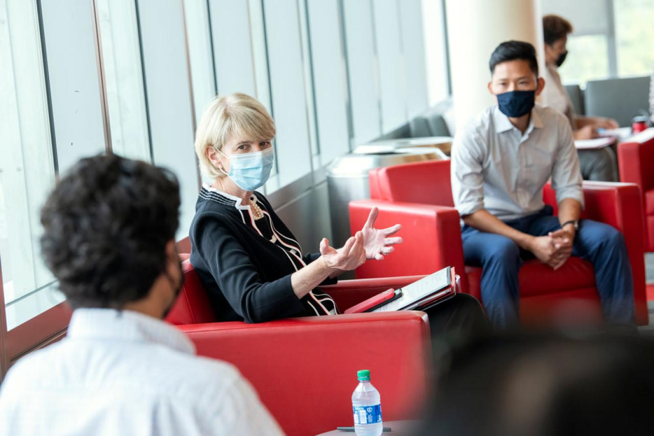 Image of Ohio State President Kristina Johnson speaking with two students while seated