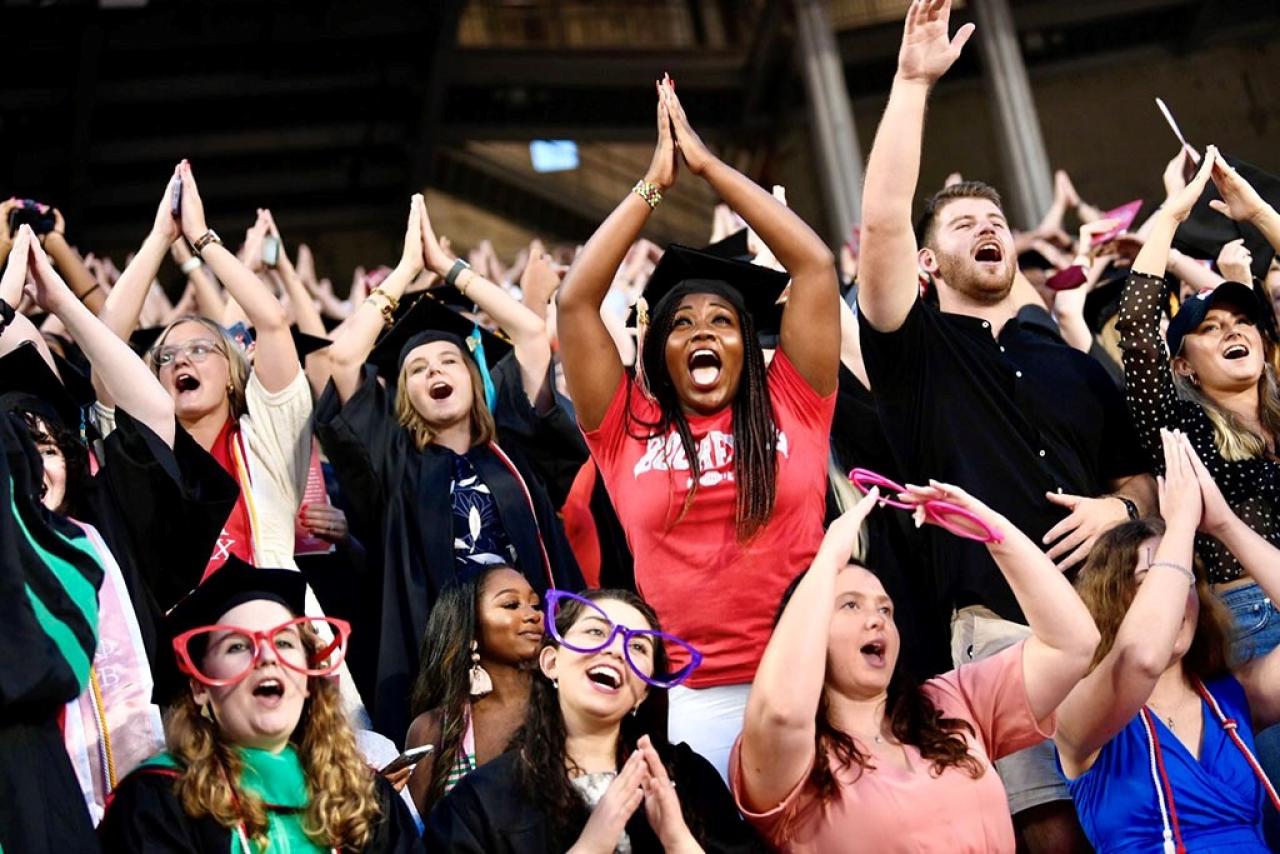 Ohio State graduates making O-H-I-O during a graduation celebration