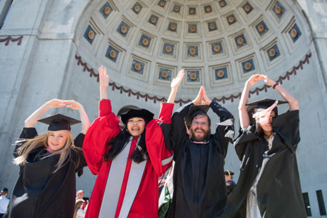 Image of Ohio State graduates forming O-H-I-O with their arms