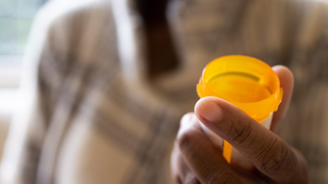 Closeup of a pill bottle in a person's hand